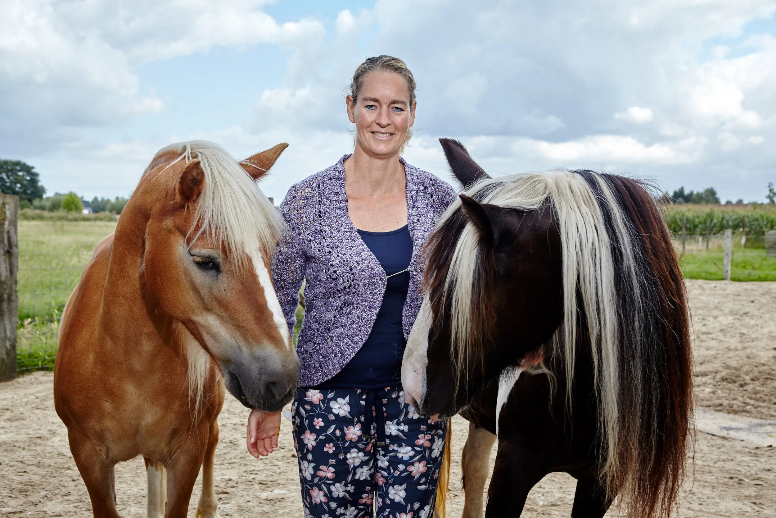 Els met twee van haar paarden op het erf